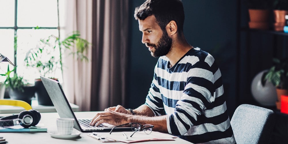 A man working on his laptop at home.